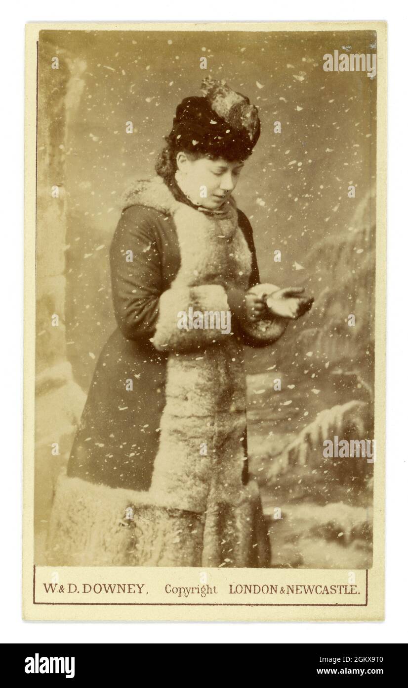 Carte de visite victorienne originale (CDV), éventuellement envoyée sous forme de carte Chrismas, d'une femme portant un chapeau et un manteau vêtu de fourrure, effet flocon de neige, par des photographes renommés de la Reine Victoria, W & D Downey de Londres et Newcastle, Angleterre Royaume-Uni vers 1881 Banque D'Images