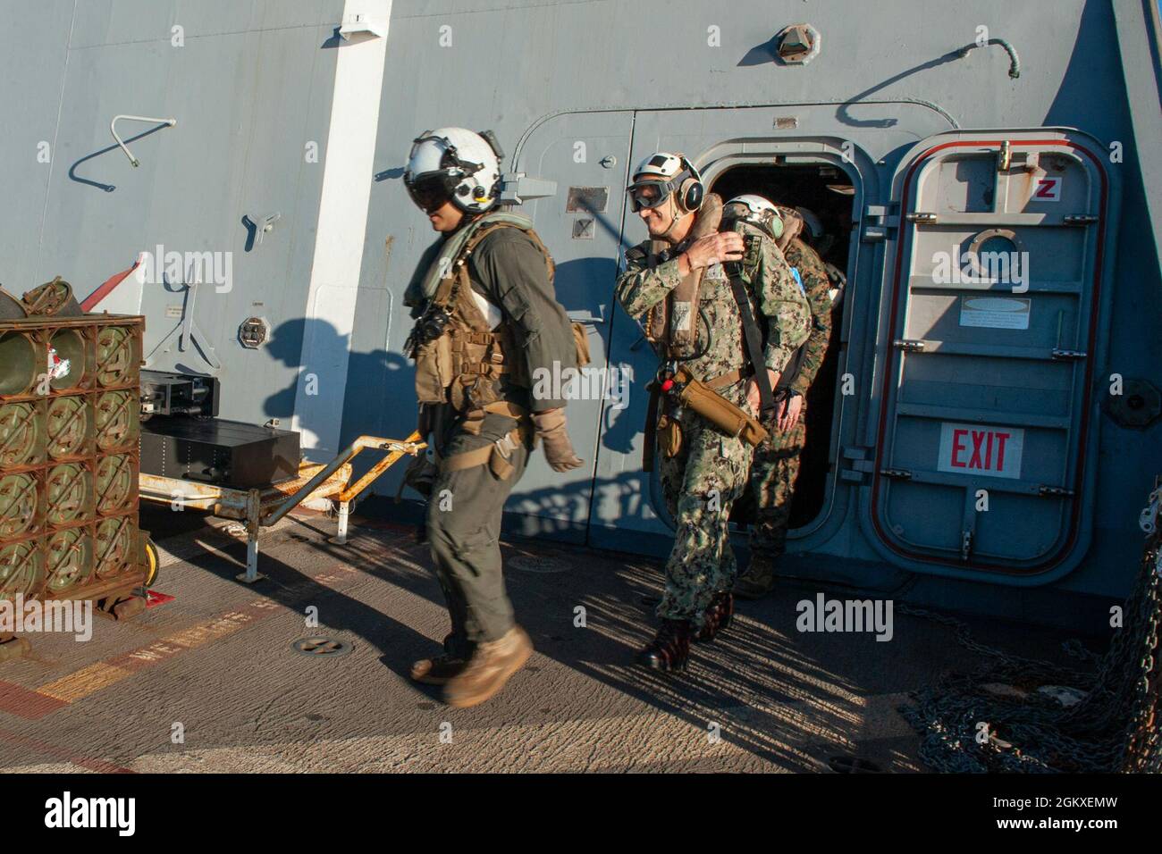 210718-N-XB010-1046 CORAL SEA (18 juillet 2021) le capitaine Greg Baker, commodore, Escadron amphibie 11, à droite, quitte l'USS New Orleans (LPD 18). La Nouvelle-Orléans, qui fait partie de l'America Expeditionary Strike Group, ainsi que la 31e Marine Expeditionary Unit, opère dans la zone de responsabilité de la 7e flotte des États-Unis pour améliorer l'interopérabilité avec les alliés et les partenaires et servir de force d'intervention prête pour défendre la paix et la stabilité dans la région Indo-Pacifique. Banque D'Images