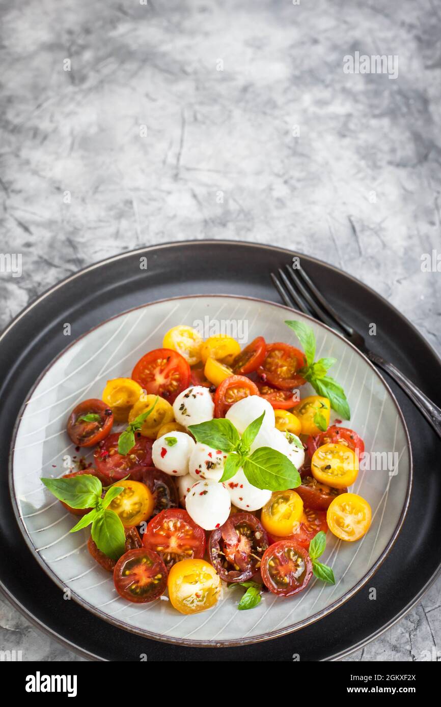 Salade de tomates cerises rouges et jaunes fraîches, fromage mozzarella et basilic, gros plan Banque D'Images