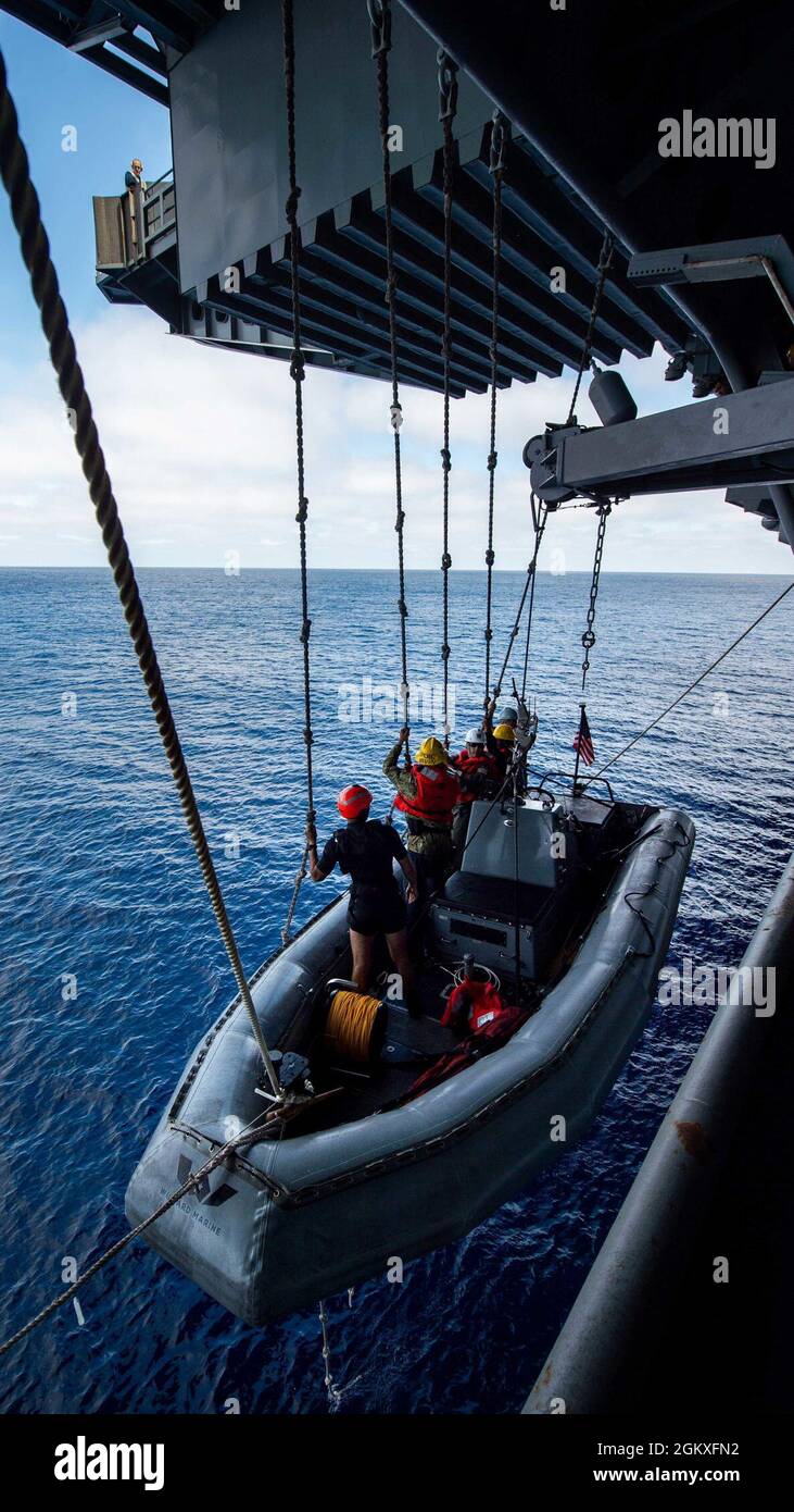 210719-N-HS181-2102 OCÉAN PACIFIQUE (le 19 juillet 2021) des marins élèvent un bateau gonflable à coque rigide jusqu'au pont tribord du porte-avions de la classe Nimitz USS Carl Vinson (CVN 70), le 19 juillet 2021. Vinson mène actuellement des opérations maritimes de routine dans la 3e flotte des États-Unis. Banque D'Images