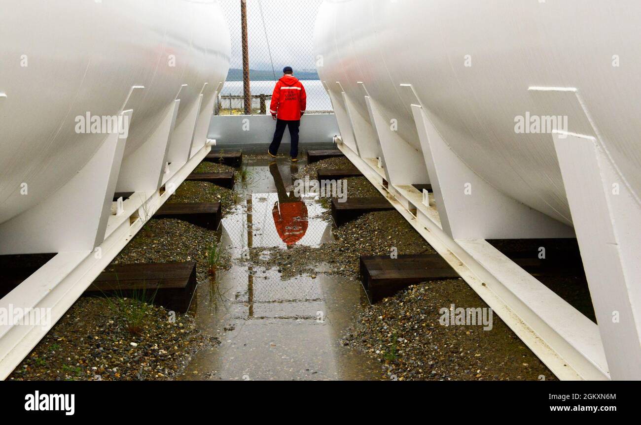 Le sous-officier de 2e classe Craig Bennett, technicien en sciences de la mer du Groupe de travail sur la sécurité maritime de la Garde côtière, inspecte une installation de stockage de mazout à Teller, en Alaska, le 20 juillet 2021. Dans le cadre de l'inspection, les membres du FSTM discutent des plans d'intervention, examinent la documentation et inspectent l'équipement et les installations de stockage du carburant afin d'assurer la conformité réglementaire. Banque D'Images