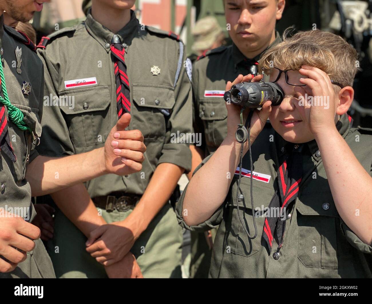 Les membres de la ZHR (Association scoute de la République) ont une expérience pratique avec une vue d'arme thermique lors d'une exposition d'équipement de groupe de combat en Pologne à la zone d'entraînement de Bemowo Piskie, Pologne, le 22 juillet 2021. Le Groupe de combat Pologne a invité les scouts à BPTA pour établir des relations communautaires. Banque D'Images
