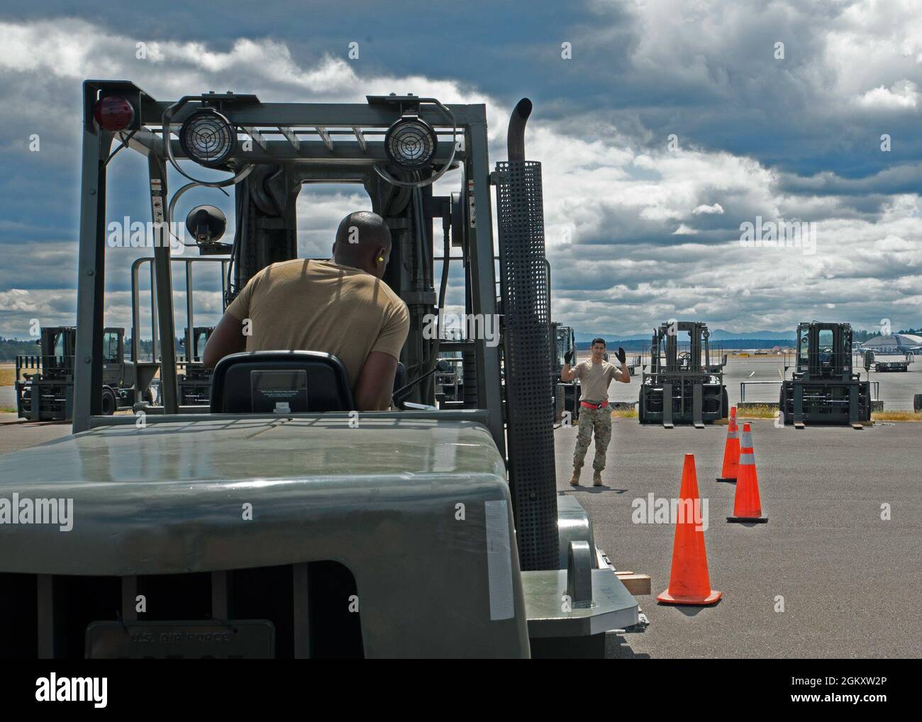 (De gauche à droite) Sgt. Wesley Valentine, superviseur du service passagers au 62e Escadron du port aérien, observe les signaux de U.S. Air Force Tech. Sgt. Emmanuel Escobar, 62e superviseur du fret aérien de l'APS, en préparation au rodéo de Port Dawg de la Force aérienne du Pacifique (PACAF) de 2021 à la base conjointe Lewis-McChord (Washington), le 21 juillet 2021. L'équipe se rendra à la base conjointe Pearl Harbor-Hickam, à Hawaï, pour participer aux côtés d'autres escadrons de ports aériens dans cinq événements différents : une accumulation de palettes, un cours de compétences de chariot élévateur de 10K, un centre de marquage d'équilibre et un test de connaissances, un avion téléverser un Banque D'Images
