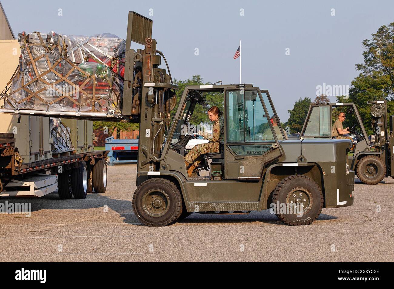 TSgt Elizabeth Wood entraîne un chariot élévateur (avant) TSgt Doug Hermansen pilote de l'équipement de charge de fond du chariot élévateur de la 127e Escadre, Michigan Air National Guard, sur un camion à la base de la Garde nationale de Selfridge Air, Michigan ici le 28 juillet 2-21. L'équipement a été chargé par des aviateurs du 127e Escadron de préparation logistique de la Garde nationale aérienne du Michigan, qui fournit une fonction de terminal aérien (ATF) aux unités militaires de l'État du Michigan. Banque D'Images