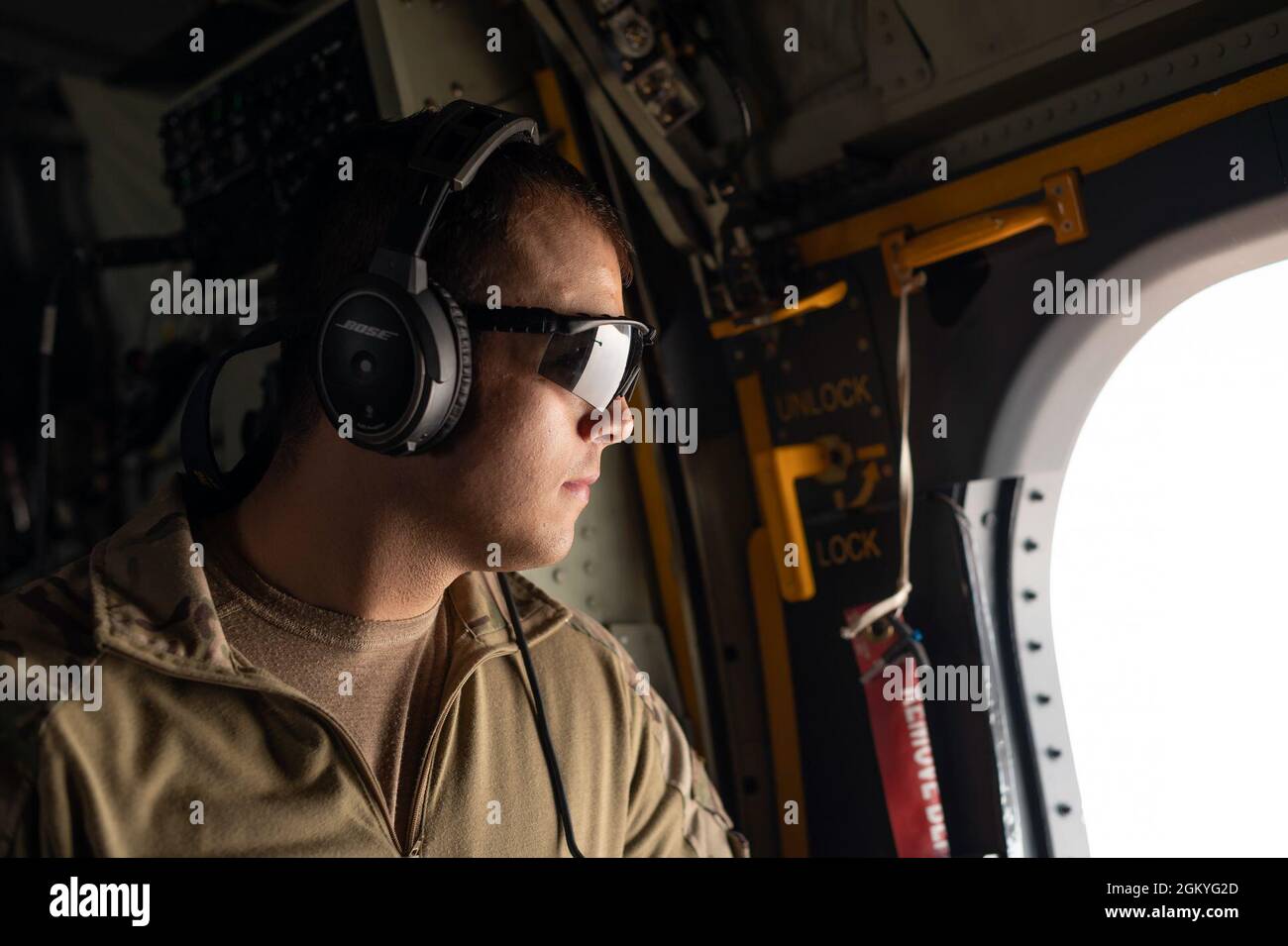 Un Airman américain du 26e Escadron de sauvetage expéditionnaire regarde la fenêtre d'un HC-130J combat King II pendant un exercice le 28 juillet 2021, à un endroit non divulgué quelque part en Asie du Sud-Ouest. Le 26e ERQS est à l'affût de la zone de responsabilité du Commandement central des États-Unis, offrant une capacité de transport de navires-citernes pour les hélicoptères HH-60G Pave Hawk associés et pouvant également fournir un point de ravitaillement en carburant dans les endroits austères. Banque D'Images