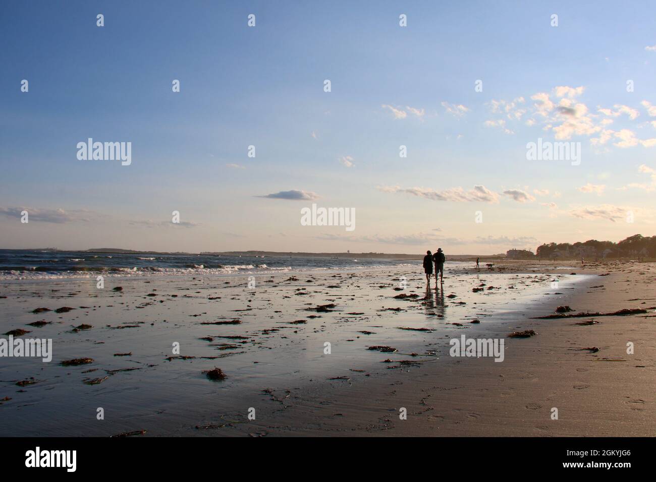 Deux figures en silhouette promenade sur une plage dans le Maine en soirée Banque D'Images