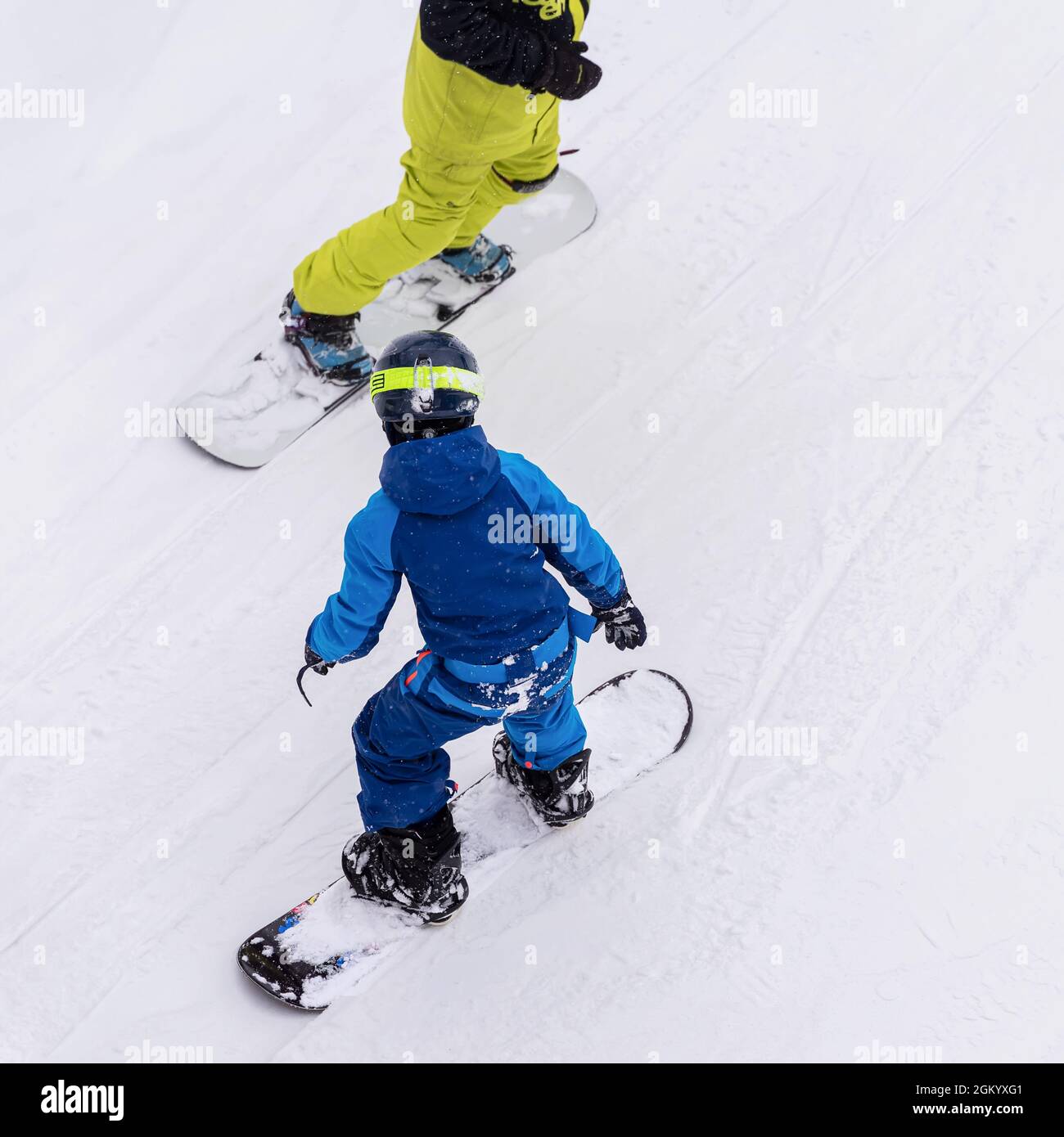 Vue arrière du père avec enfant sur le snowboard, la piste de ski. Loisirs d'hiver, style de vie sportif, entraînement au ski et vacances familiales en plein air Banque D'Images