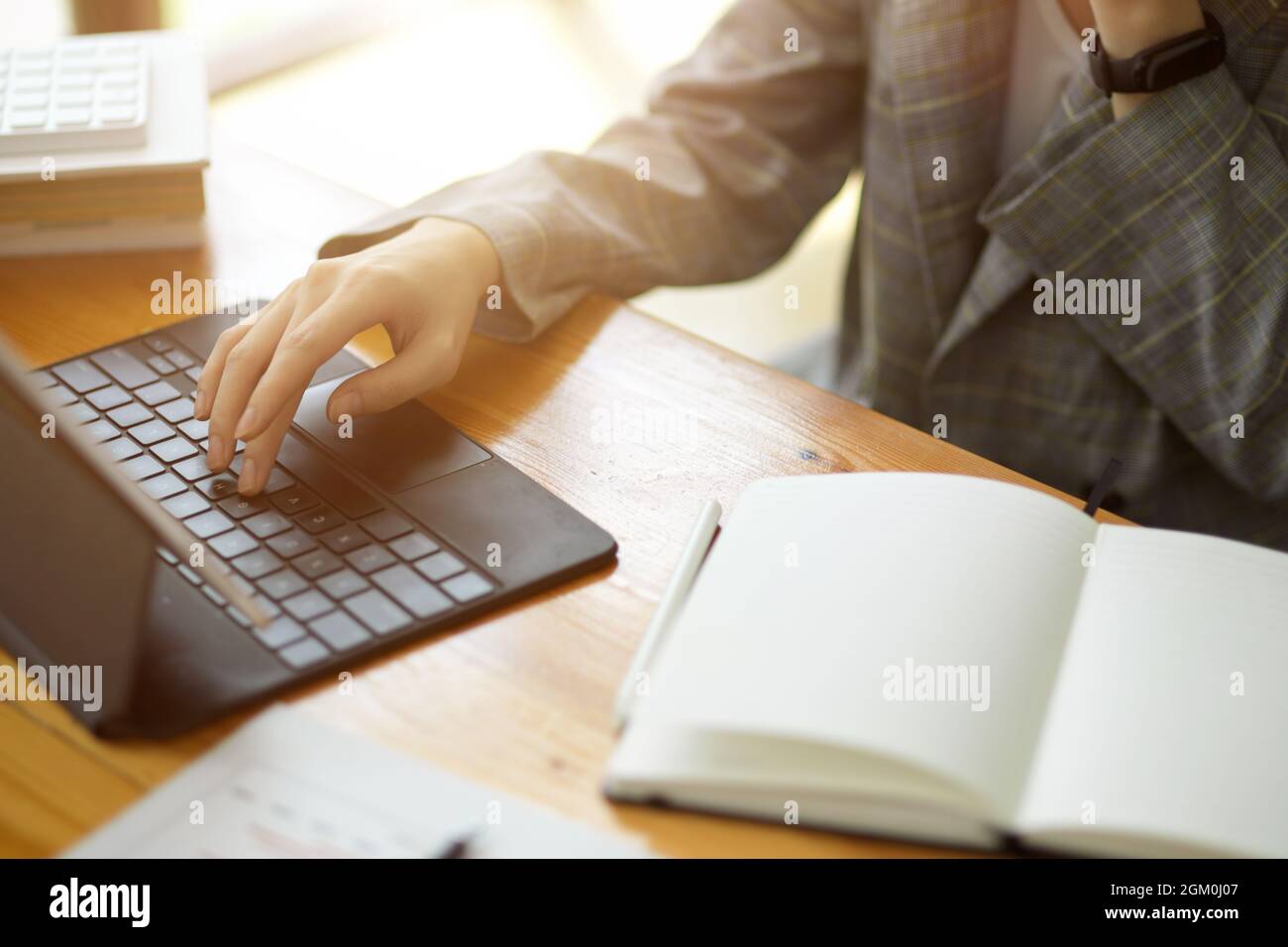 Gros plan, femme d'affaires tapant sur tablette clavier portable avec ordinateur portable vierge sur le bureau Banque D'Images