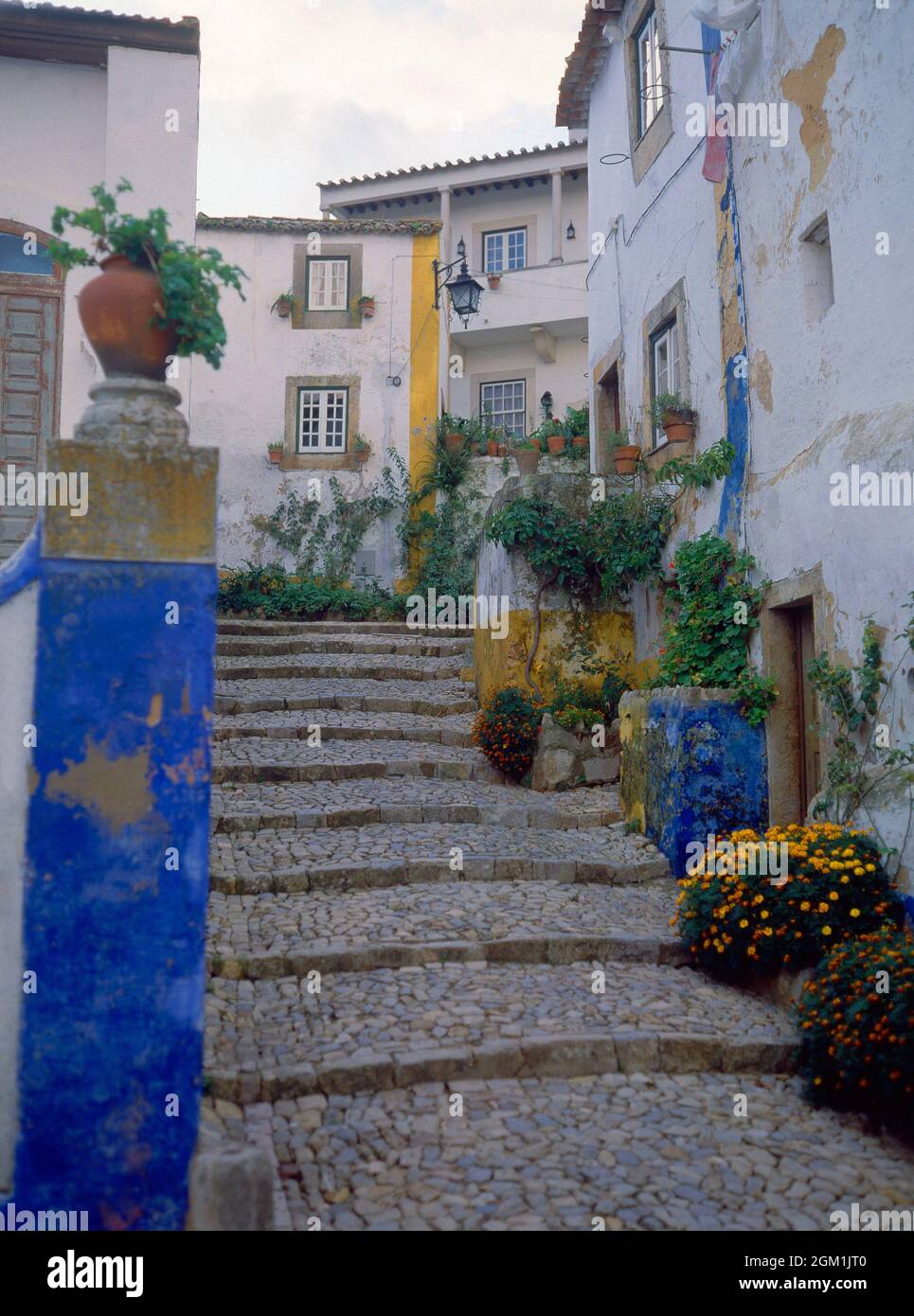 ESCALERA EMPEDRADA - CASAS BLANCAS CON LOS BORDES PINTADOS DE COLORES. Emplacement : EXTÉRIEUR. OBIDOS. PORTUGAL. Banque D'Images