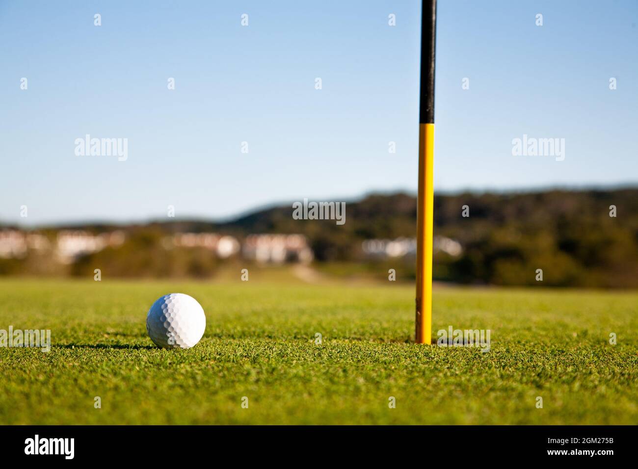 Balle de golf sur le green de mise par trou et drapeau. Ombres longues. 2008 Banque D'Images