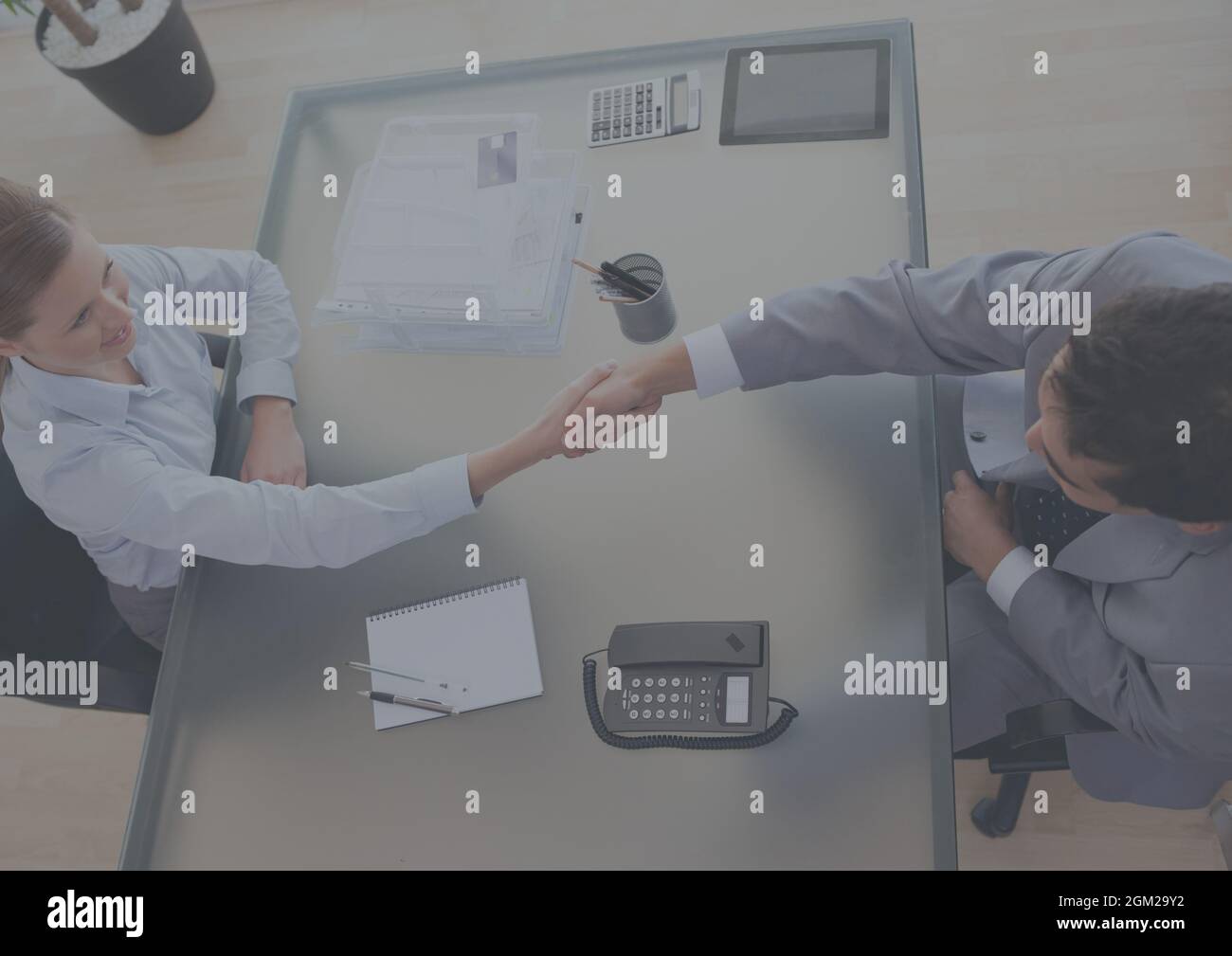 Vue aérienne de l'homme d'affaires et de la femme d'affaires qui se secouent la main au bureau Banque D'Images