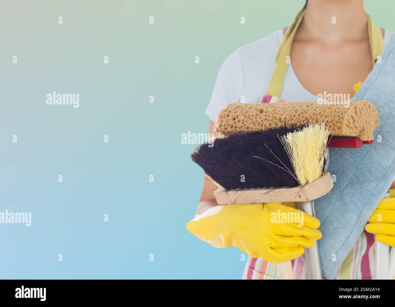 Section médiane de la femme tenant un équipement de nettoyage avec un espace de copie sur fond dégradé Banque D'Images