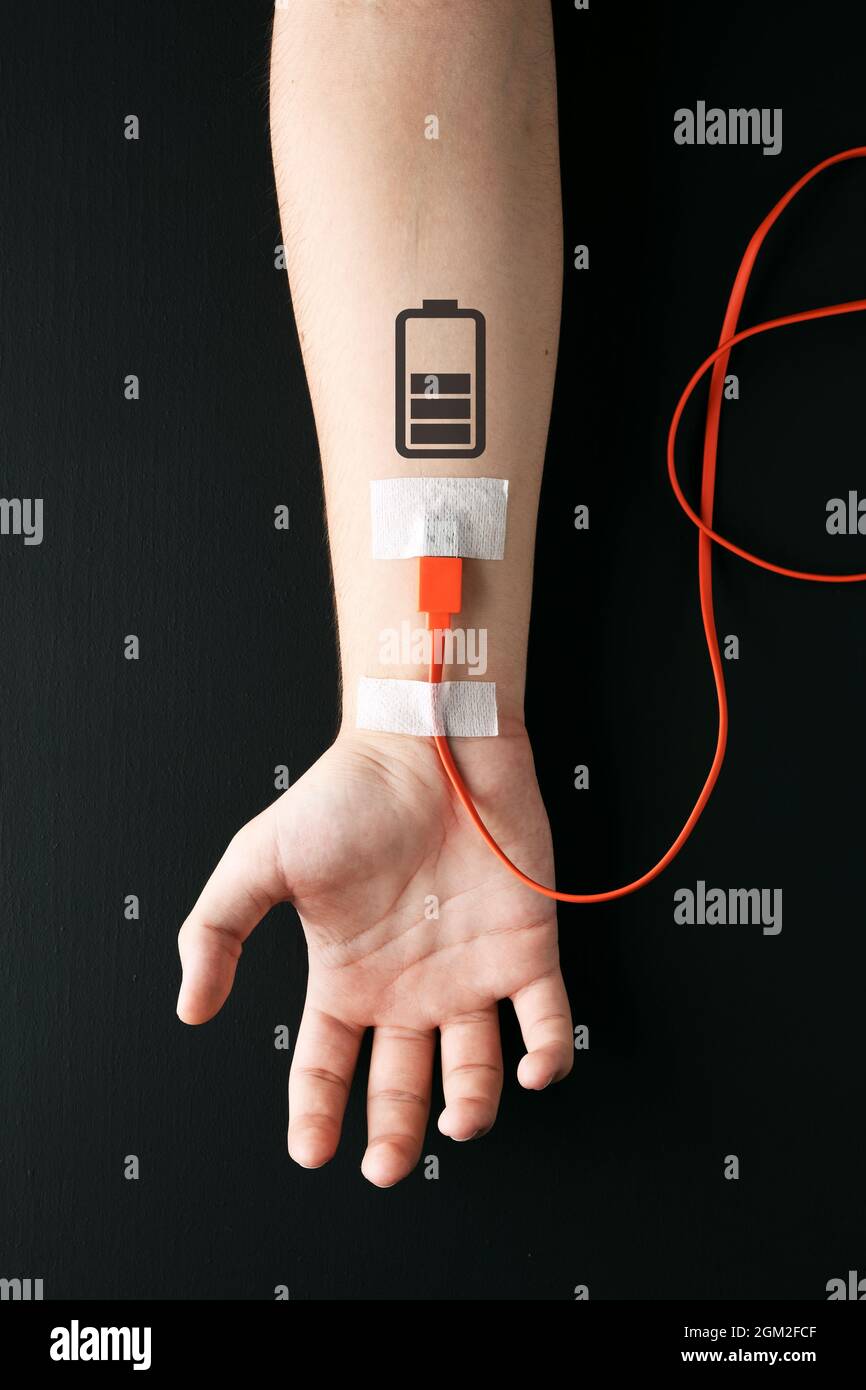 Câble de chargement USB branché sur un bras mâle avec symbole de chargement de la batterie. Fatigue, recharge, surcharge, épuisement, fatigue ou concept d'énergie de la vie. Banque D'Images