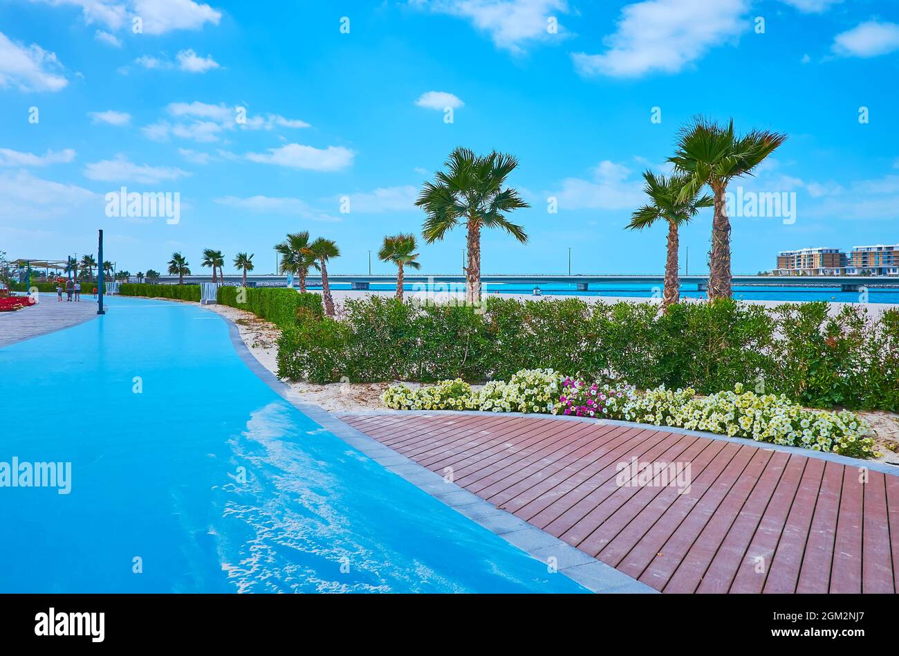 La piste de jogging en caoutchouc courbe bleu vif s'étend le long de la plage de Jumeirah, Dubaï, Émirats arabes Unis Banque D'Images