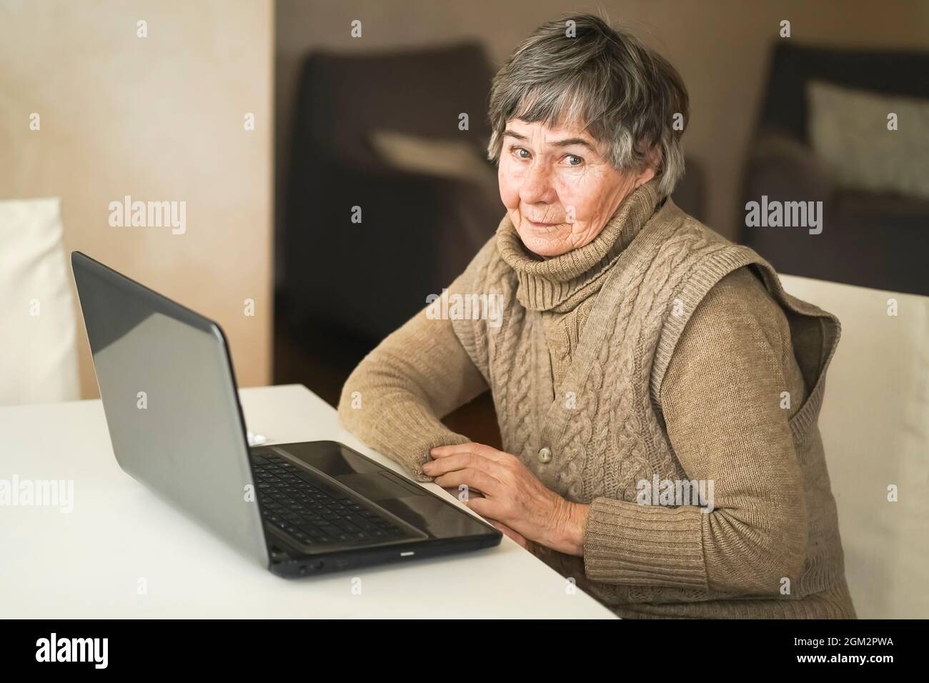 Vieille femme smiley lisant des nouvelles en ligne. Banque D'Images