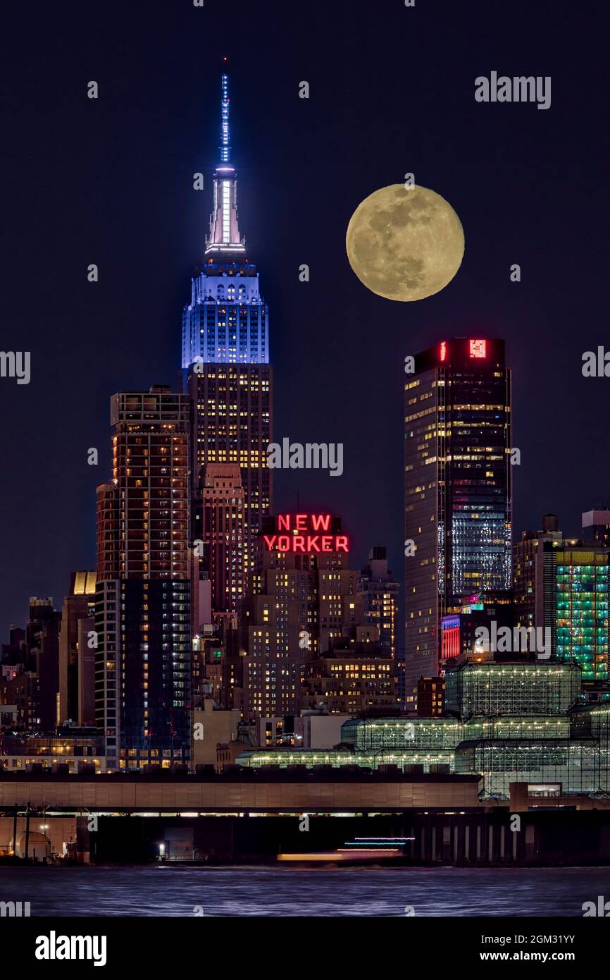 Empire State ESB Super Moon NYC - vue sur l'emblématique monument urbain de l'Empire State Building éclairé en blanc et bleu. On voit aussi le New Yorker Banque D'Images