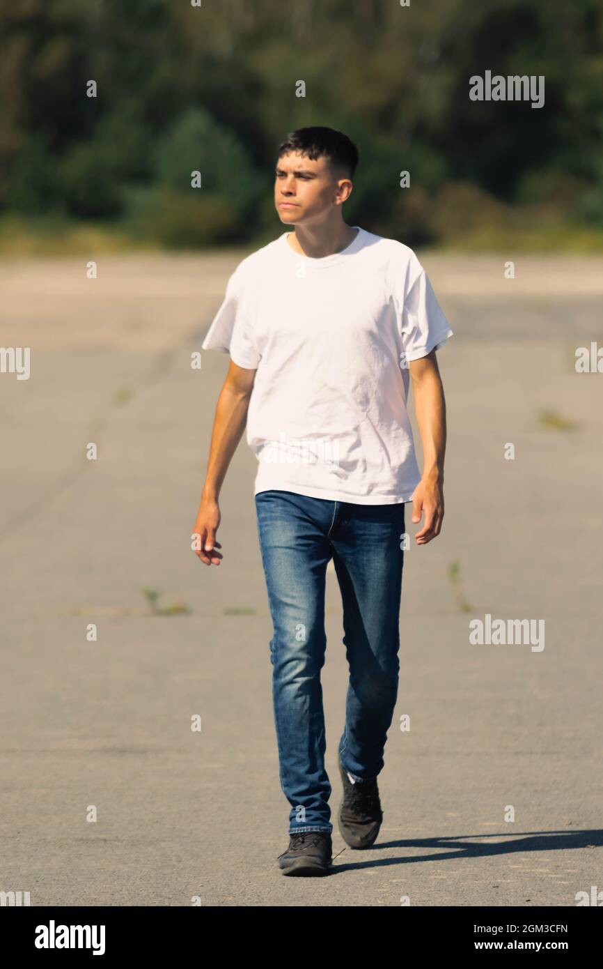 jeune garçon de 18 ans dans un t-shirt blanc à l'extérieur et jeans en denim  bleu Photo Stock - Alamy