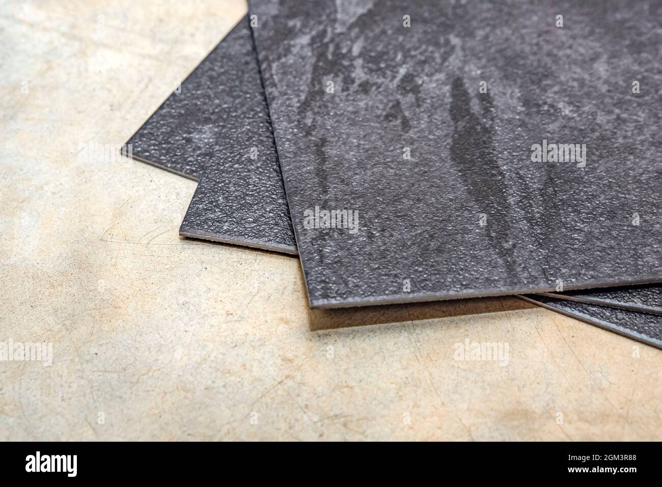 Plancher en PVC vinyle. La texture du plancher en vinyle est noire. Échantillons de revêtement en vinyle, carreaux en pvc noir sur sol en béton avant l'installation. Banque D'Images