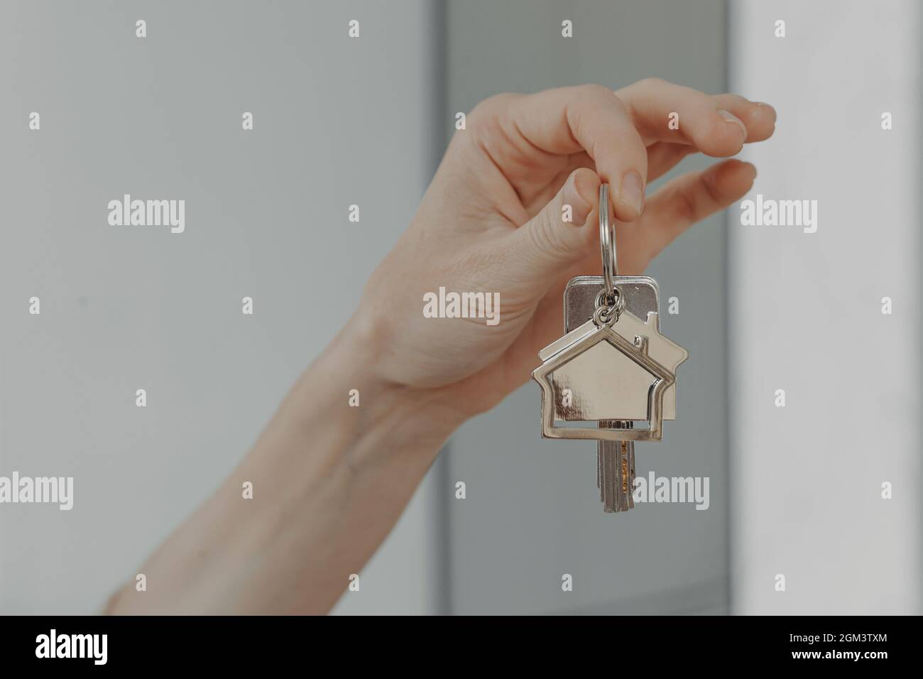 Femme tenant le porte-clés en forme de maison, foyer sélectif sur la main femelle avec la clé de la nouvelle maison Banque D'Images