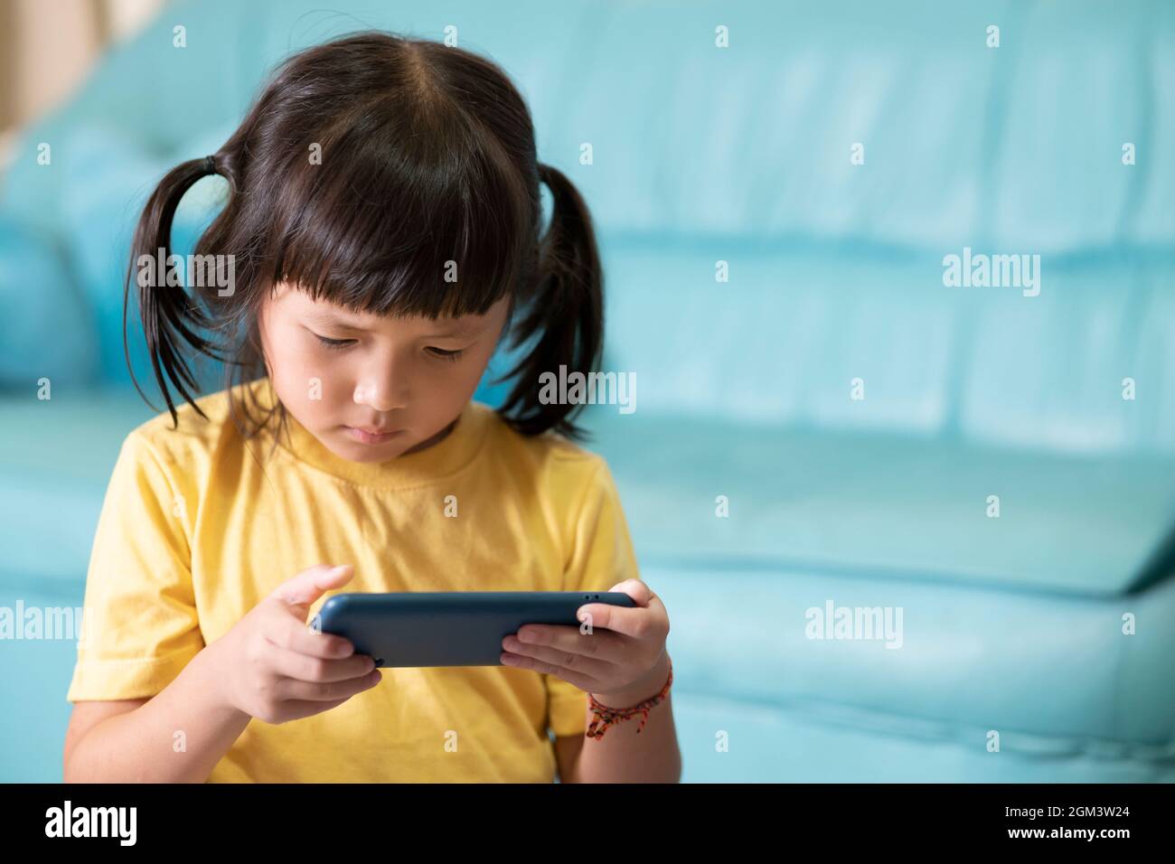 Yeux fatigués et fatigue de l'utilisation du téléphone pendant une longue période, enfant jouant à des jeux en ligne. Internet ou addict de jeu en ligne Banque D'Images