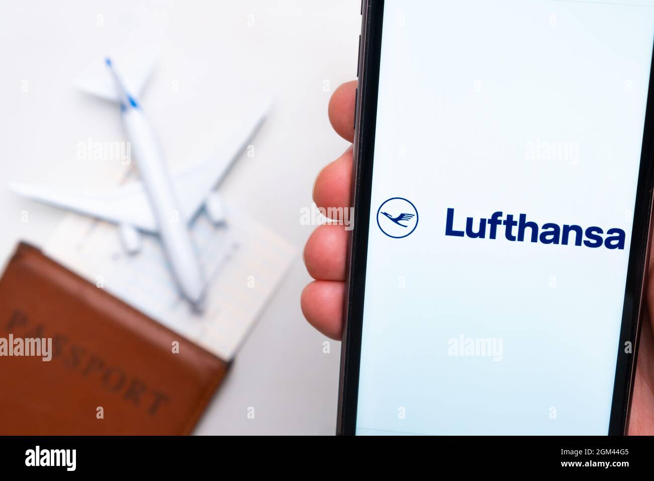 Application ou logo de la compagnie aérienne Lufthansa affiché sur un téléphone mobile avec passeport, carte d'embarquement et avion en arrière-plan, septembre 2021, San Banque D'Images