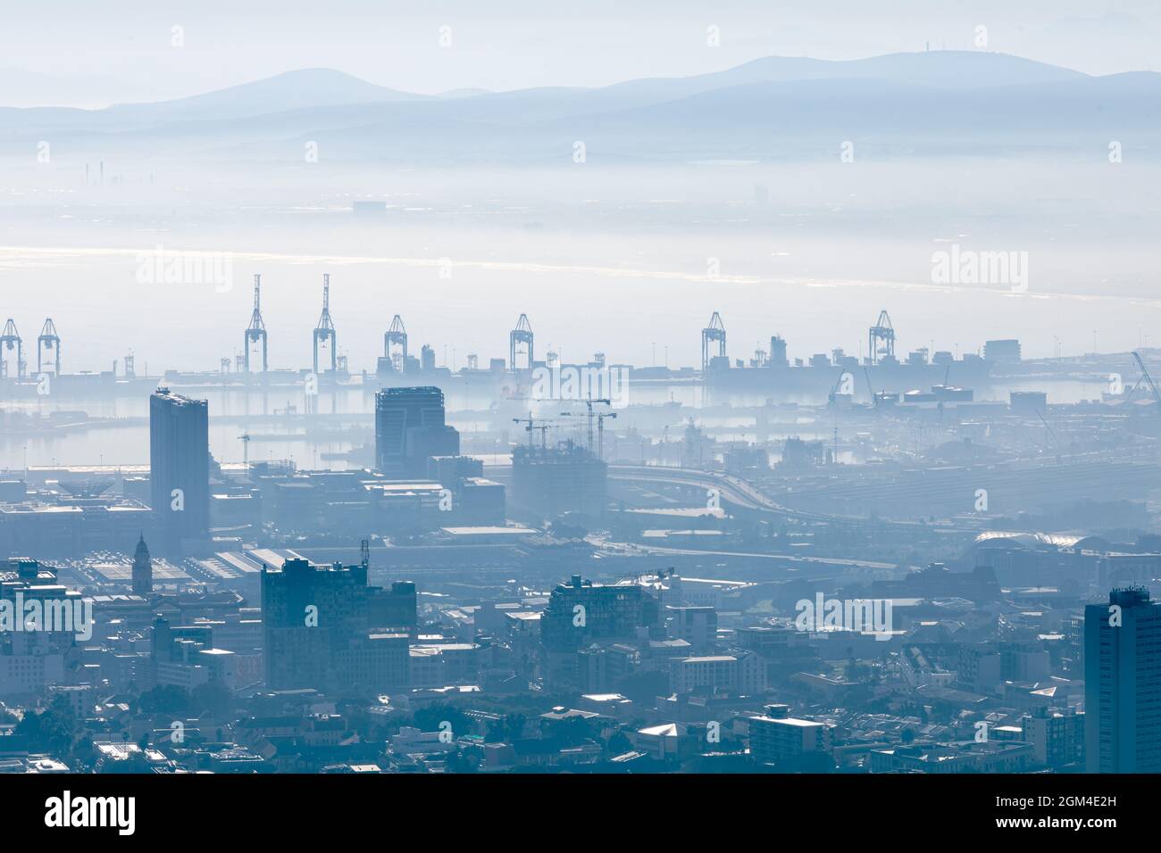 Vue générale du paysage urbain avec plusieurs bâtiments modernes et grues le matin brumeux Banque D'Images