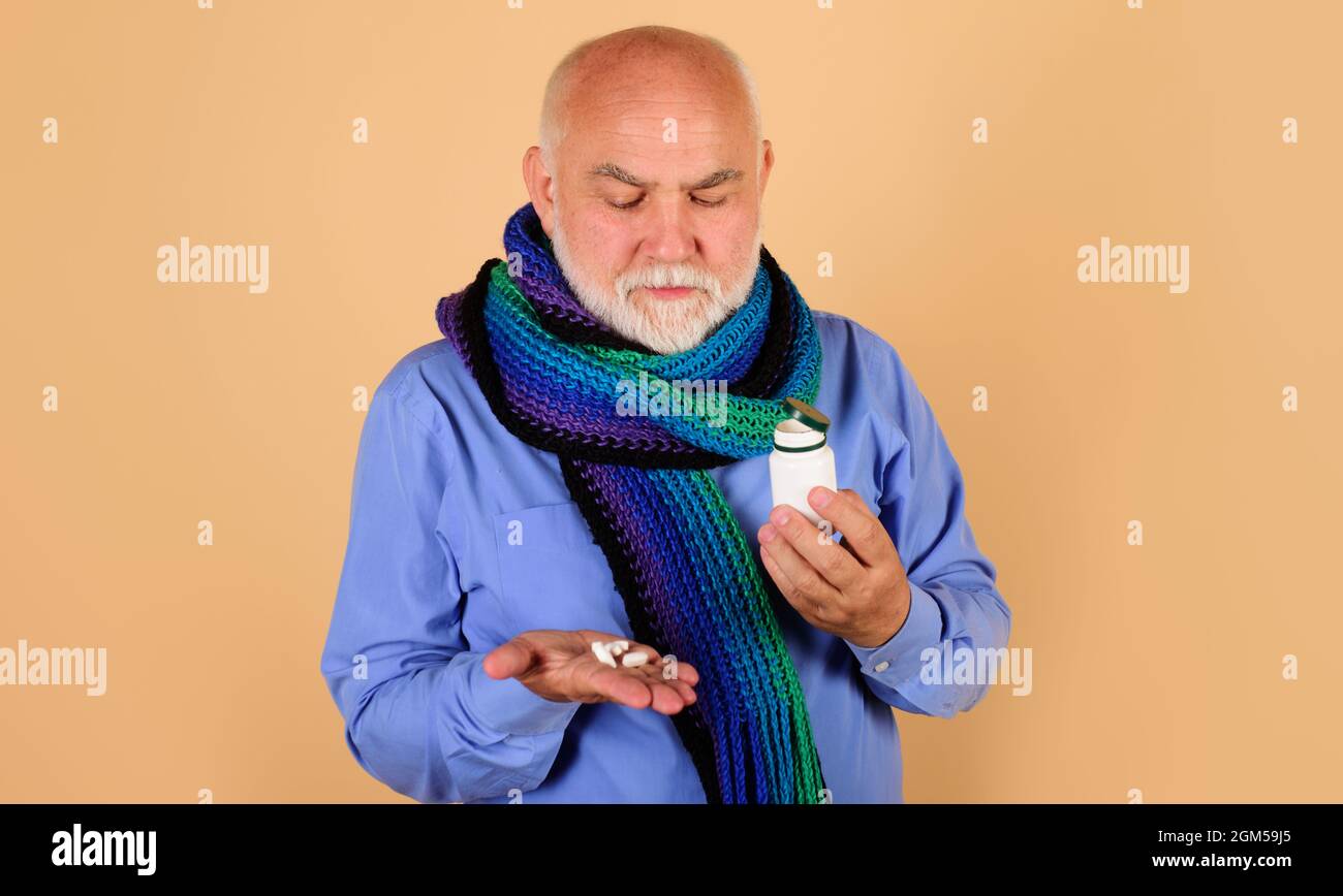 Homme barbu avec des pilules à la main. Homme avec bouteille de médicament pilule. Homme malade prenant un comprimé. Banque D'Images