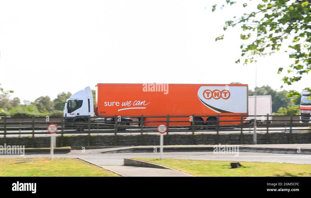 Camion de la chaîne logistique de livraison TNT voyageant sur la M27 près de Southampton. Prise de vue panoramique latérale montrant le logo avec espace de copie. Banque D'Images