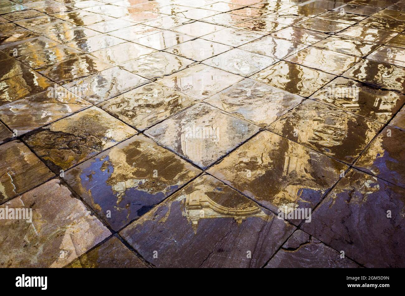 Grenade, Andalousie, Espagne : Cathédrale reflétée sur le pavé humide de la place Plaza de las Pasiegas. Banque D'Images