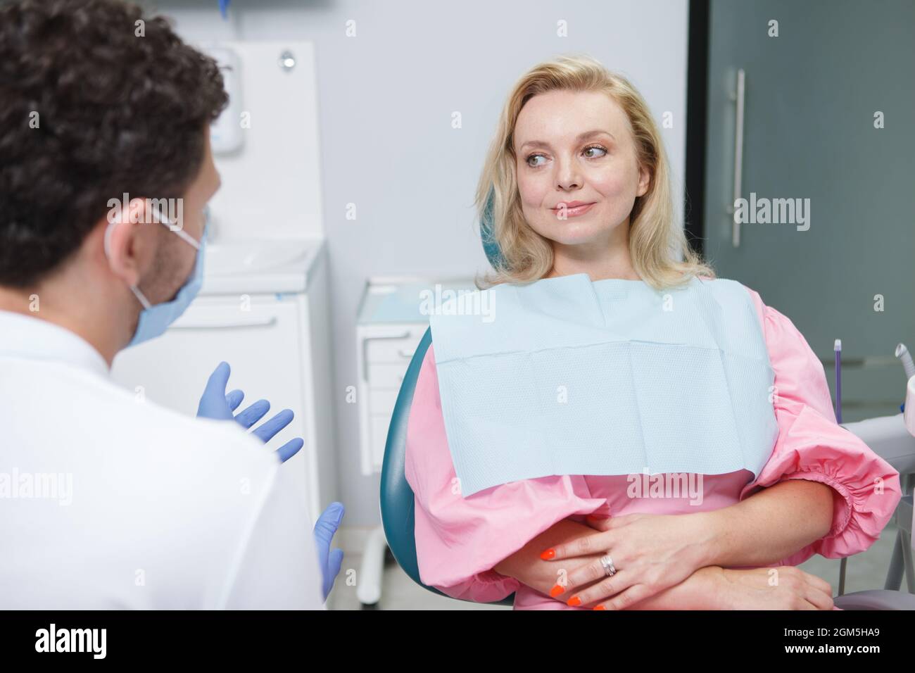 Patiente gaie parlant à son dentiste Banque D'Images