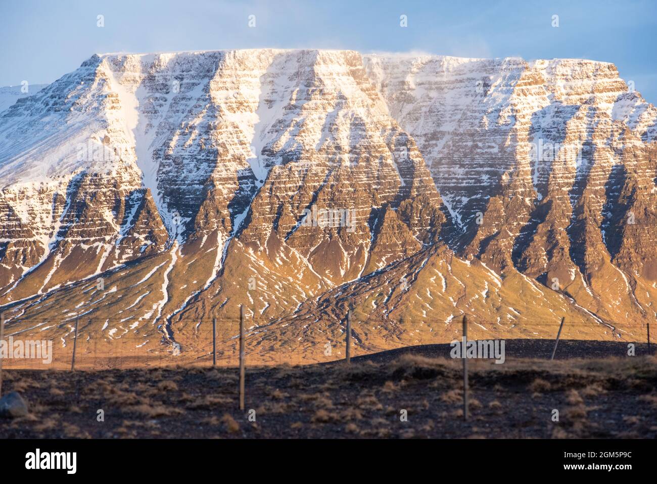 Golden hour éclairage phénomène géologique en Islande neige cagoule vent de montagne soufflerie gel texture couches paysage falaises bords wow Banque D'Images