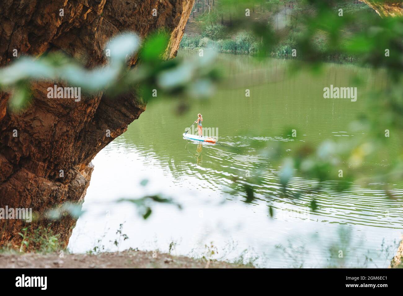 La jeune femme mince en costume vert sur le bateau de sup avec le char flottant sur la rivière, voyage de week-end et Voyage local Banque D'Images