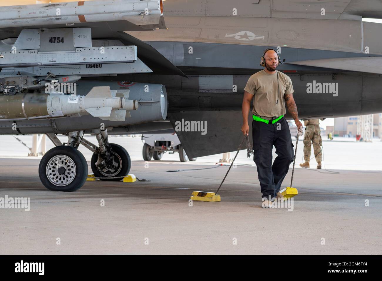 Un chef d'équipage de l'armée de l'air des États-Unis, au 121e Escadron de génération de chasseurs expéditionnaires, retire les cales des roues d'un faucon de combat F-16 en préparation au roulement à la base aérienne de Prince Sultan, Royaume d'Arabie saoudite, le 27 août 2021. En plus du soutien logistique et de la main-d’œuvre, la 378e Escadre expéditionnaire aérienne a fourni une force aérienne de combat pour assurer la supériorité aérienne du Commandement central des États-Unis pendant les opérations d’évacuation non combattantes en Afghanistan. (É.-U. Photo de la Force aérienne par le sergent d'état-major. Caleb Pavao) Banque D'Images