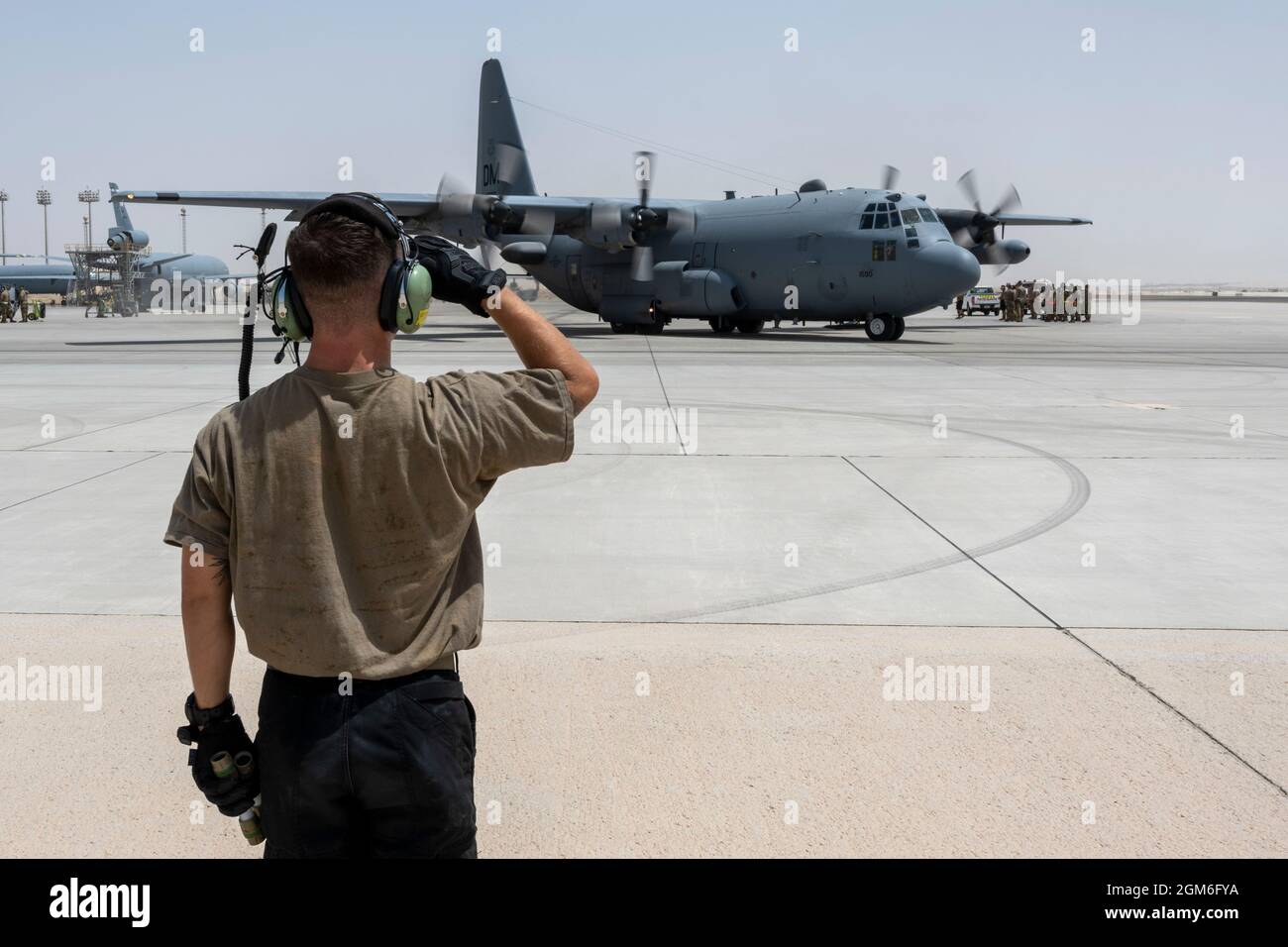 Un Airman de la Force aérienne des États-Unis, avec le 380e Escadron de maintenance d'aéronefs expéditionnaires, salue un avion Compass Call EC-130H alors qu'il se prépare à partir de la base aérienne d'Al Dhafra, aux Émirats arabes Unis, à l'appui de l'évacuation des non combattants, août 30 2021. Le ministère de la Défense s'est engagé à appuyer l'évacuation des citoyens américains, des demandeurs de visa d'immigrant spécial et d'autres personnes à risque en provenance d'Afghanistan. (É.-U. Photo de la Force aérienne par le Sgt. Wolfram M. Stumpf) Banque D'Images