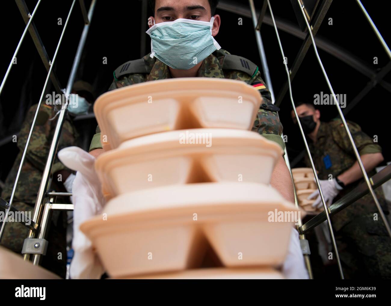 Un soldat allemand de la Bundeswehr charge des repas sur une charrette pendant le refuge de l'opération alliés à la base aérienne de Ramstein, en Allemagne, le 10 septembre 2021. Des soldats de la Bundeswehr allemande ont travaillé d'épaule à épaule avec les membres du service de l'armée et de l'armée de l'air des États-Unis pour préparer des repas pour les évacués de l'Afghanistan. La base aérienne de Ramstein est un centre de transport en commun qui offre aux personnes évacuées un endroit sûr pour remplir leurs documents, tandis que des vérifications de sécurité et des antécédents sont effectuées avant de poursuivre leur destination finale. (É.-U. Photo de l'armée par le sergent d'état-major. Thomas mort) Banque D'Images