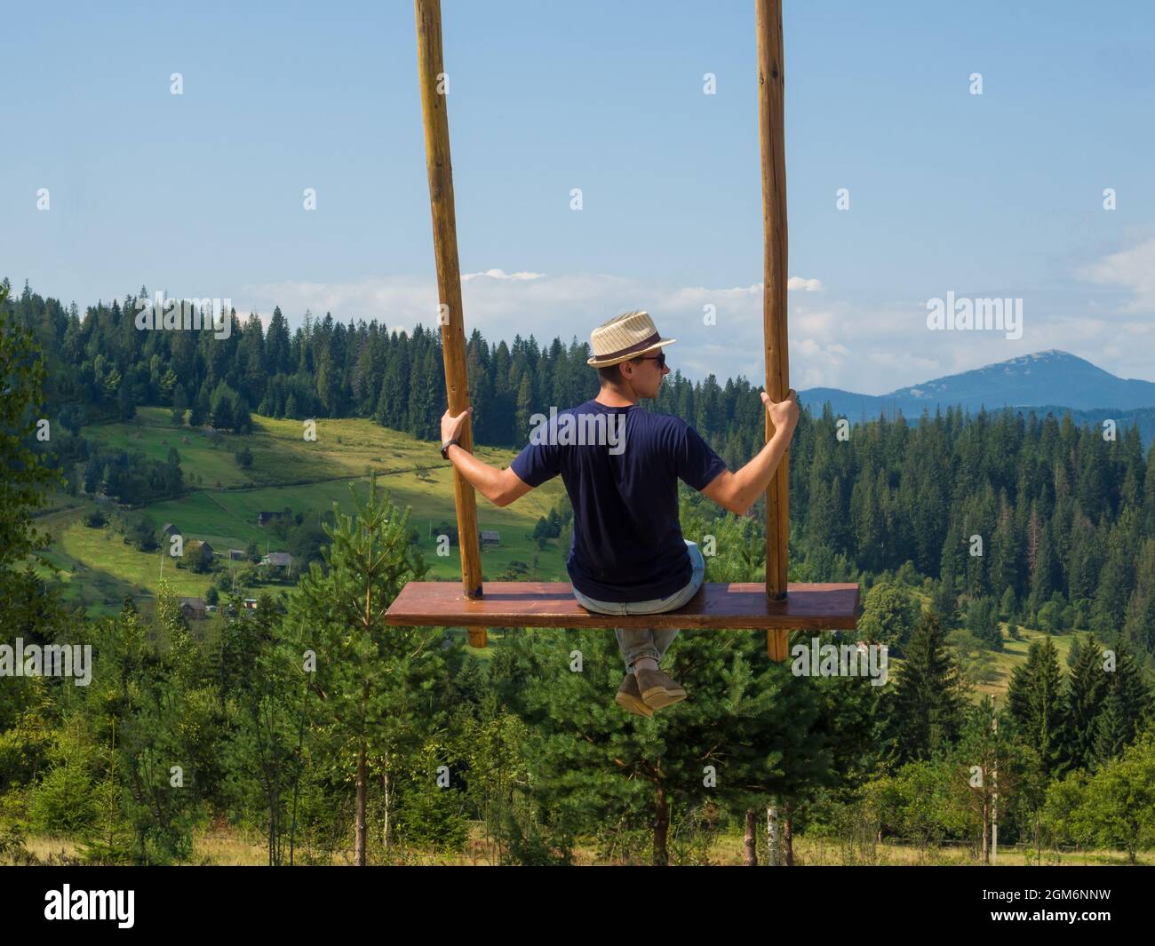 homme voyageur appréciant de balancer sur l'oscillation céleste et la vue sur la montagne Banque D'Images