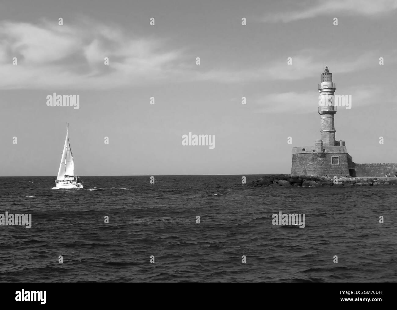 Phare historique du Vieux Port de Chania avec un bateau à voile, île de Crète, Grèce en Monochrome Banque D'Images