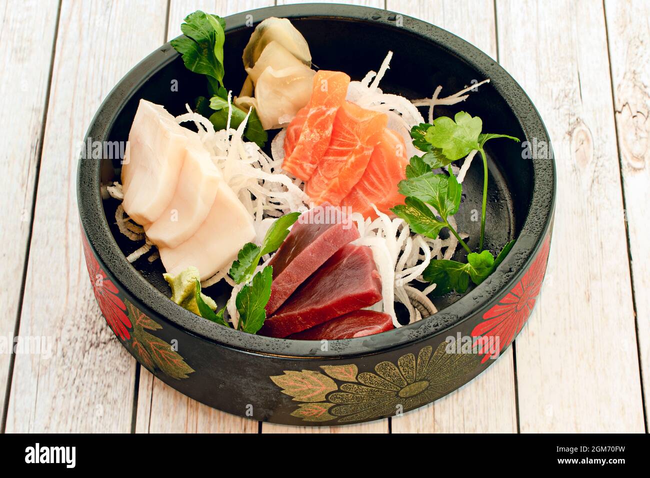 Plateau à motifs floraux noirs de style asiatique rempli de tacos sushi au saumon norvégien, de thon rouge, de babeurre et de nouilles de riz au persil frais Banque D'Images