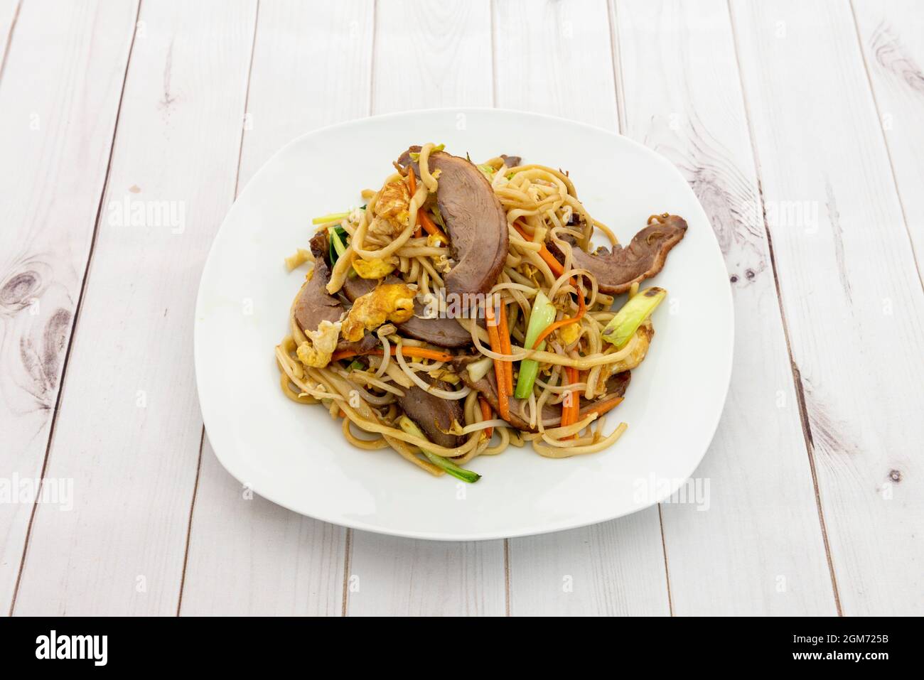 Assiette de nouilles de restaurant asiatiques sautées avec de la viande de canard, des pousses de haricots, des légumes et des œufs frits Banque D'Images