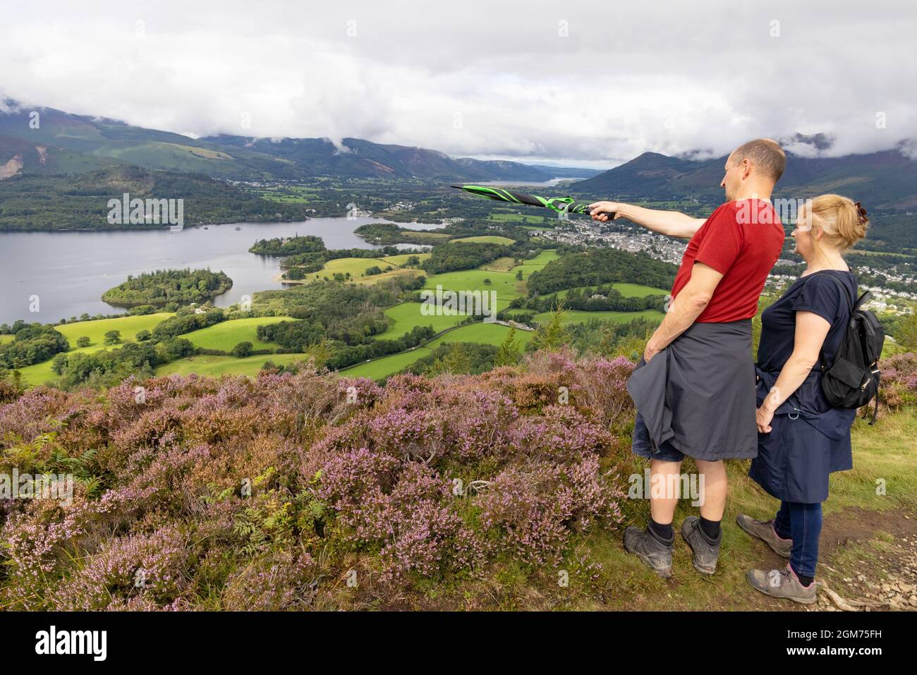 Lake District UK; un couple de marche regardant Derwentwater et Keswick de Walla Crag, Lake District National Park, Cumbria UK Banque D'Images