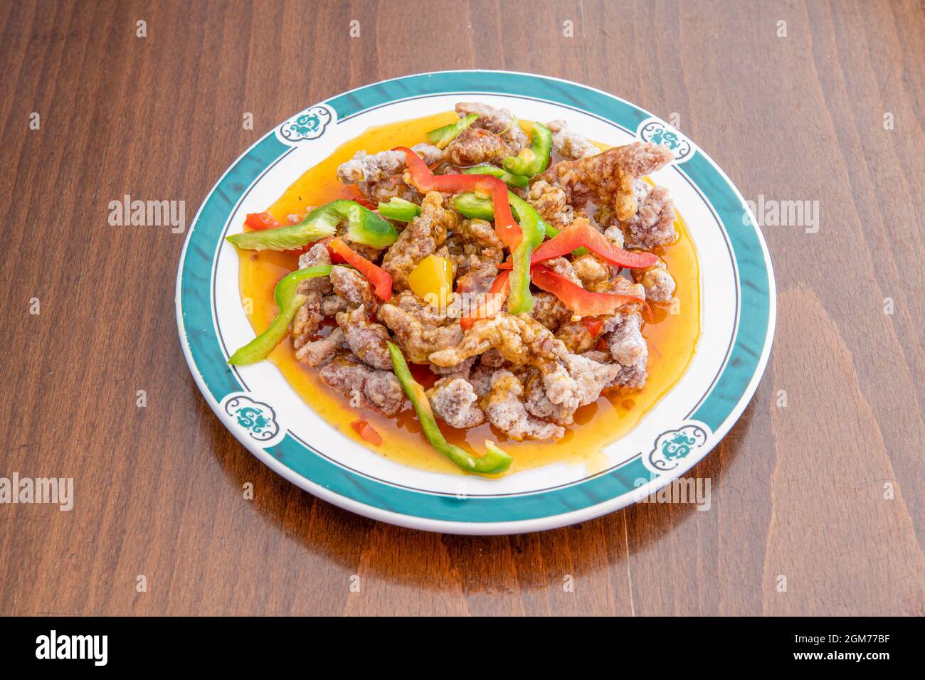 Assiette de boeuf en lanières avec des tranches de légumes sautées dans le  wok cuisiné avec une recette chinoise de boeuf de Hong Kong dans une  assiette avec des dragons verts Photo