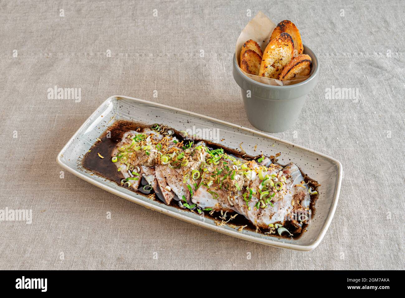 Recette espagnole de tiradioto de bar de mer cru avec sauce soja et pain grillé Banque D'Images