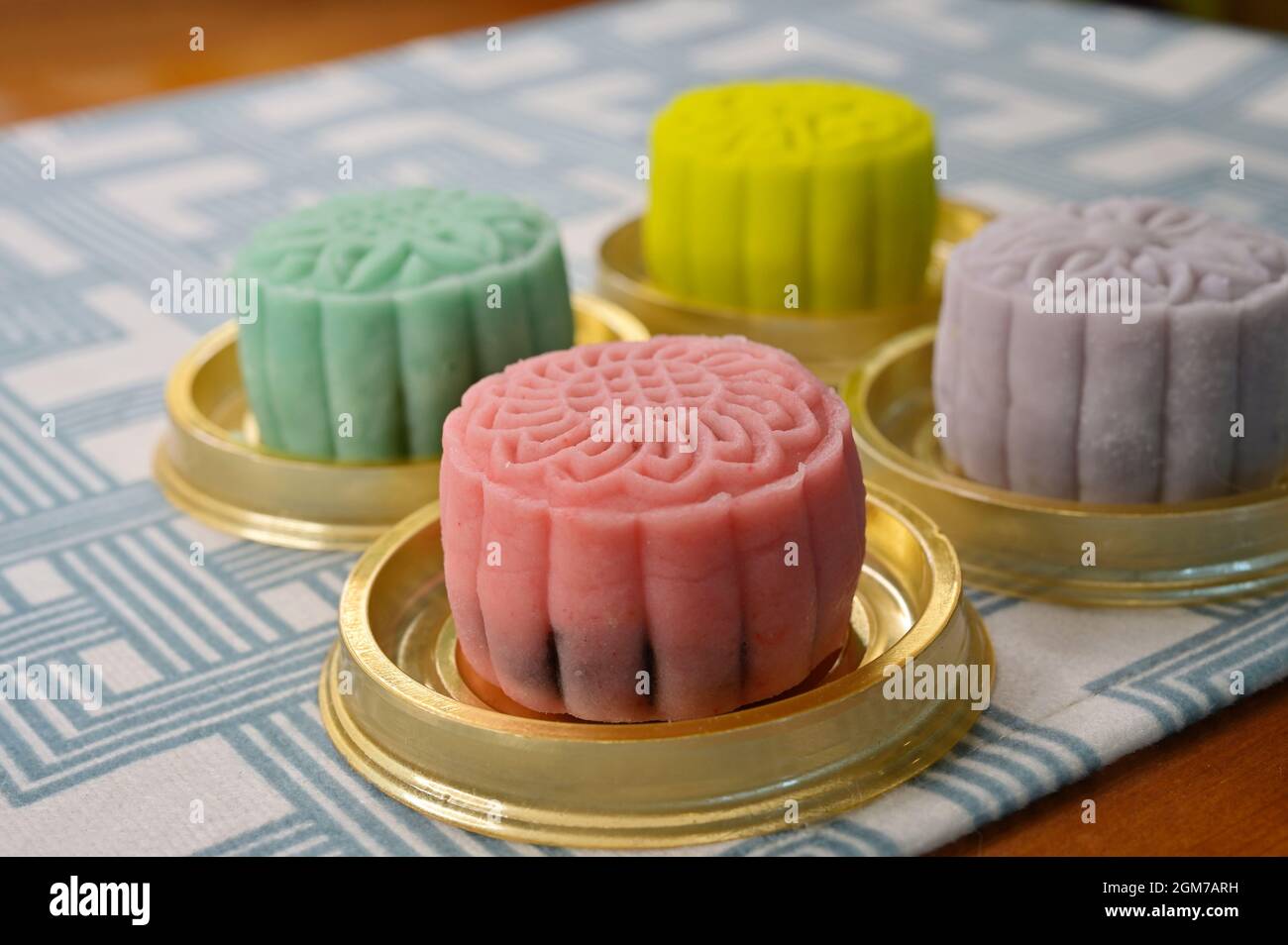 Quatre mini-gâteaux de lune à motif peau de neige avec imprimés floraux sur la nappe à carreaux Banque D'Images