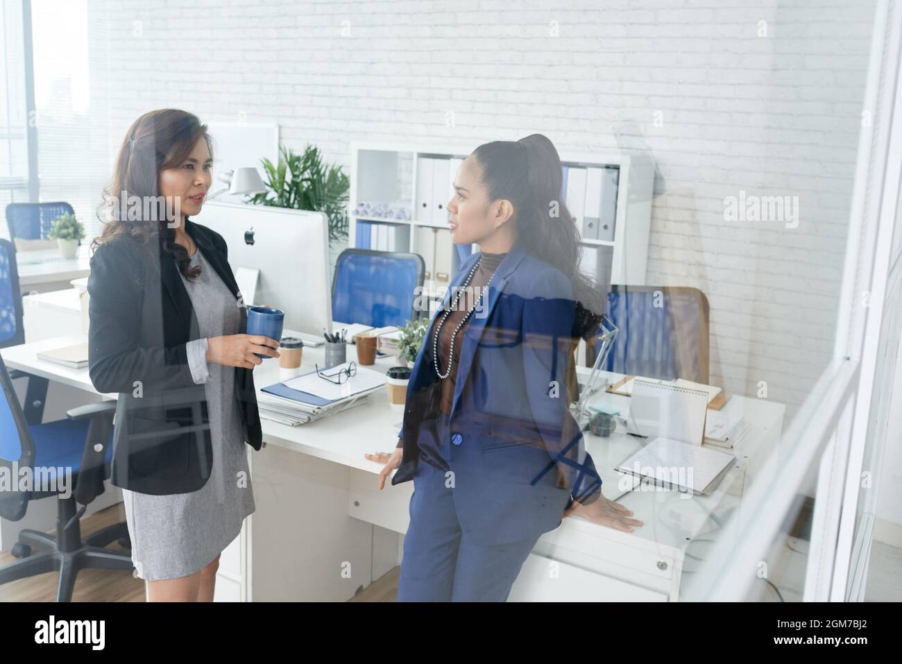 Des femmes entrepreneures sérieuses discutant des nouvelles sur le développement de l'entreprise pendant la pause-café Banque D'Images