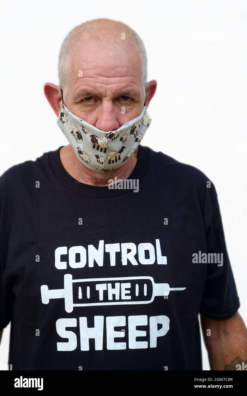 anti vaccin mâle portant un théoricien de conspiration t.shirt et masque de visage représentant des moutons Banque D'Images
