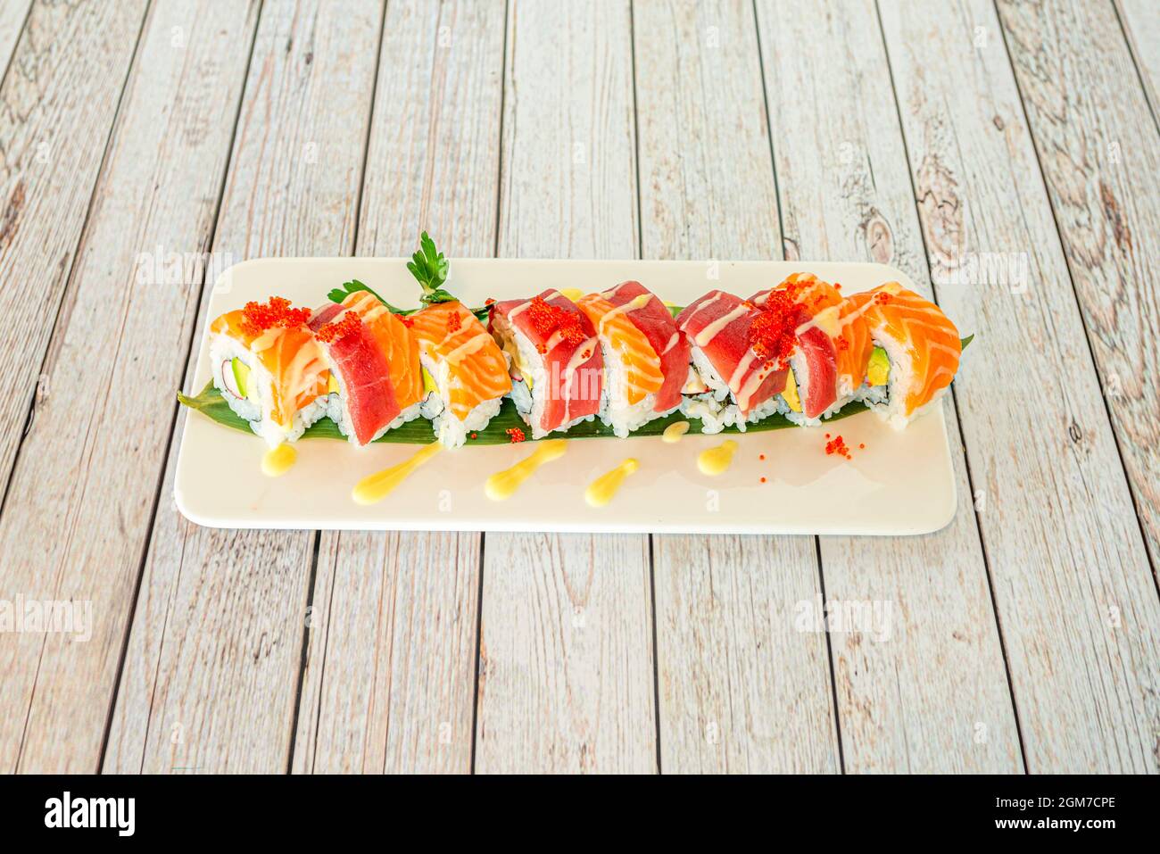 Roul de sushi uramaki mélangé avec du thon rouge et du saumon norvégien, recettes avocat, surimi, macago roe et algues nori Banque D'Images
