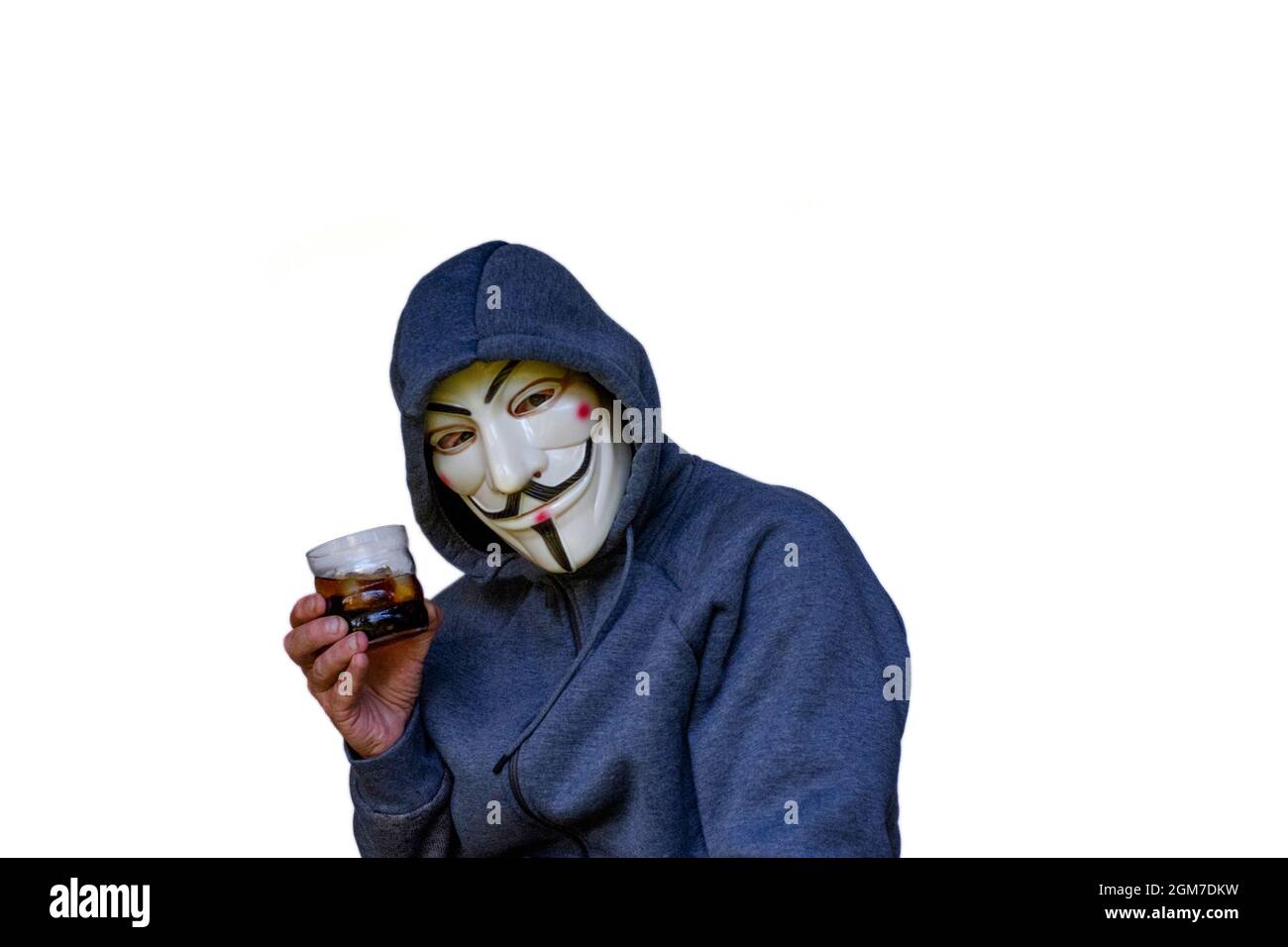 anti vaccin théoricien de conspiration masculin portant le hoodie et v pour le masque vendetta toasts avec le verre d'alcool Banque D'Images