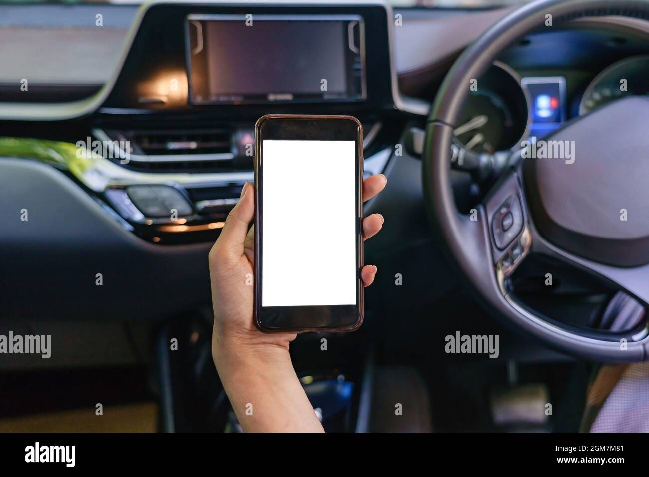 Vue de face d'un smartphone moderne avec écran vierge avec espace pour le texte ou le design, vue rapprochée des mains des femmes du conducteur à l'aide d'un téléphone portable dans une voiture Banque D'Images