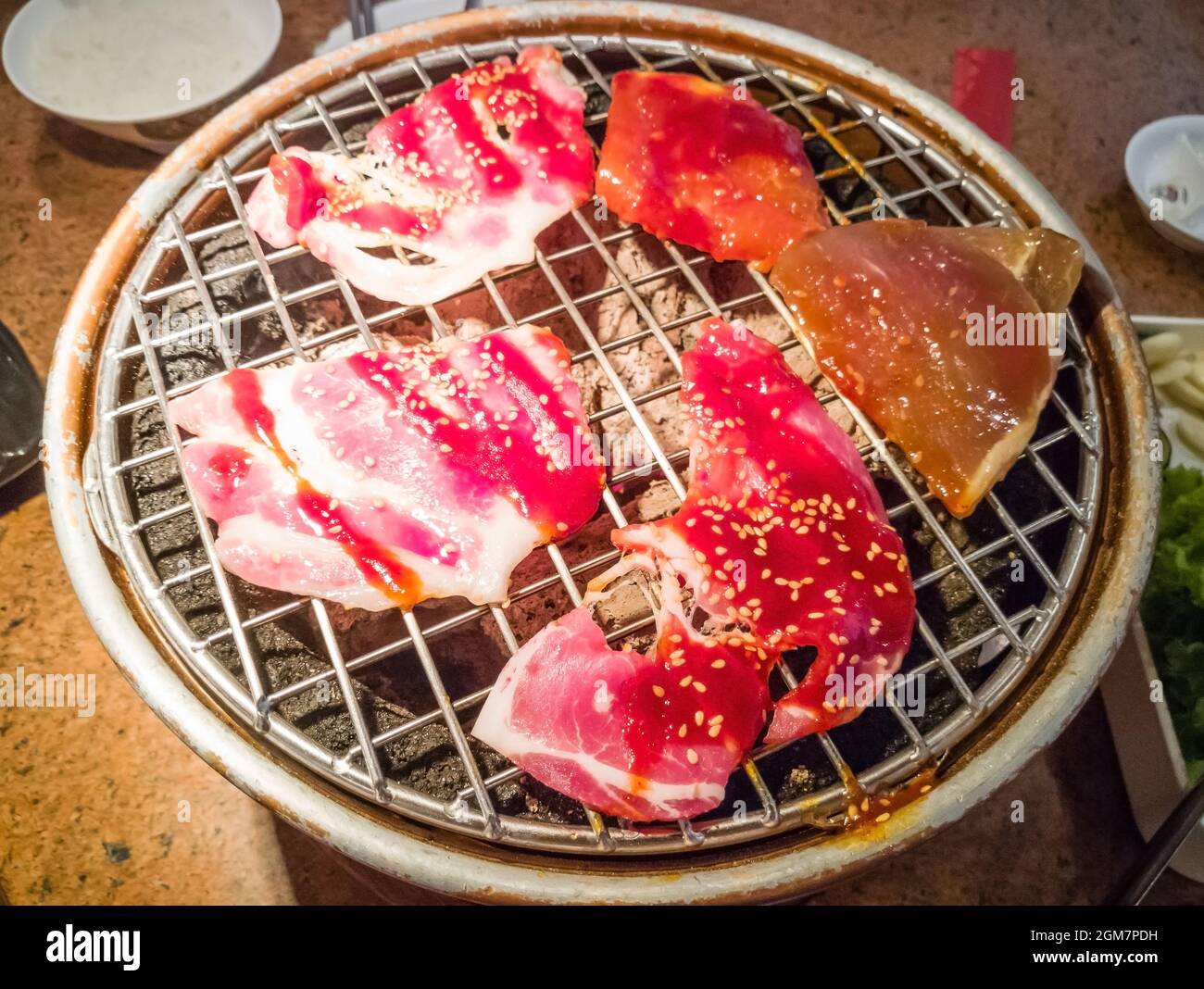 Tranche de porc de qualité supérieure grillée sur le poêle yakiniku qui a du charbon de bois chaud. Barbecue de style japonais. Image pour l'arrière-plan Banque D'Images