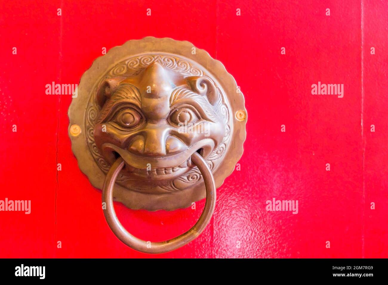 Knocker traditionnel chinois en métal sur la porte en bois rouge du temple Chin Swee, Genting Highland, Malaisie Banque D'Images